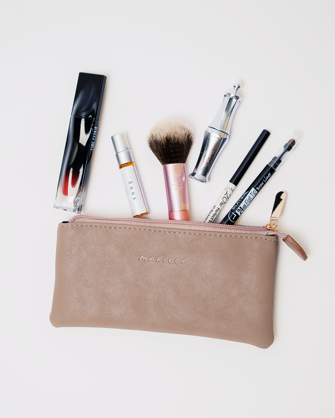 The Cloud Pouch with various makeup items on a light background