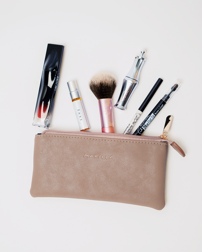 The Cloud Pouch with various makeup items on a light background